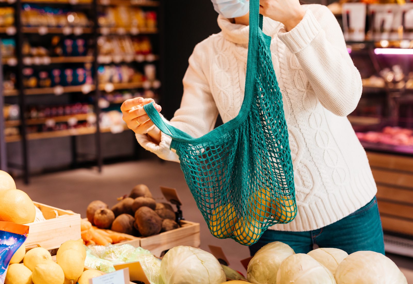 En person står vid grönsaksdisken i en gårdsbutik